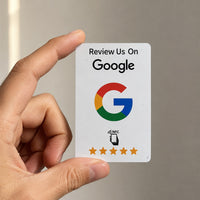 Una mano sostiene la tarjeta NFC blanca de reseñas de Google, del tamaño de una tarjeta bancaria