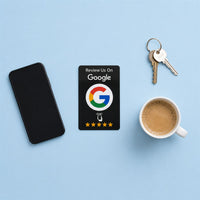 La tarjeta NFC negra sobre una mesa azul, junto a un móvil, unas llaves y un café